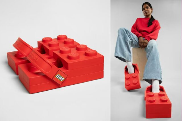 Uma pessoa vestindo Crocs vermelhos com tema Lego, jeans claros e um moletom vermelho, sentada em um bloco de madeira.