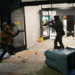 Manifestante segura cartazes durante um protesto em frente ao gabinete da senadora Amy Klobuchar, D-Minn., na segunda-feira, 26 de janeiro de 2026, em Minneapolis, depois que Alex Pretti foi morto a tiros por um oficial da Patrulha de Fronteira dos EUA no fim de semana. (Foto AP / Adam Gray)