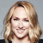 Uma mulher negra sorri na frente de um bcakdrop para o Emmy