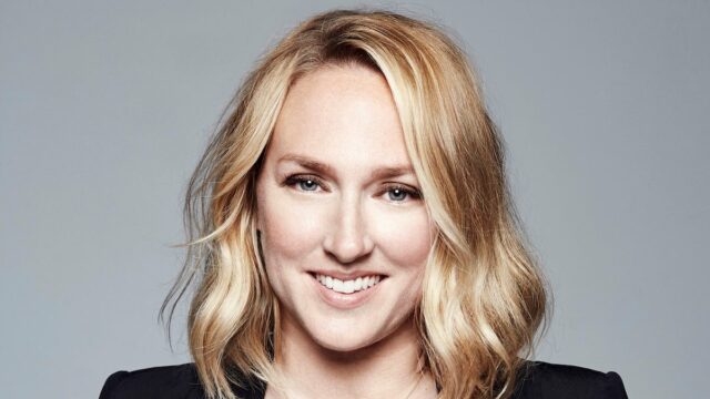 Uma mulher negra sorri na frente de um bcakdrop para o Emmy