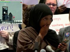 Mãe de Minnesota que criticou Trump por congelar cortes no financiamento de creches faz comentários logo depois de admitir que ‘fraude é ruim’ Uma mulher cobre a boca enquanto lê o telefone em uma coletiva de imprensa enquanto outra mulher fica atrás de um microfone à sua direita.