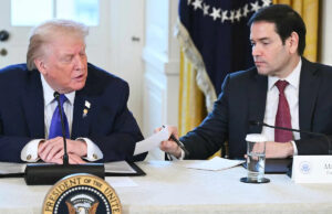 Marco Rubio apresenta nota privada a Donald Trump durante conferência de imprensa televisionada. Trump olha para baixo e lê em voz alta SAUL LOEB / AFP via Getty O presidente Donald Trump dá um tapinha nas costas do secretário de Estado Marco depois de ler em voz alta uma nota privada de Rubio durante uma entrevista coletiva em 9 de janeiro de 2026