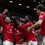 Kobbie Mainoo correndo com o uniforme do Manchester United.