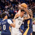 Zion Williamson (1) do New Orleans Pelicans bloqueia Michael Porter Jr. (17) do Brooklyn Nets em um jogo de basquete.