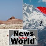 Dois turistas exploram uma praia rochosa com formações rochosas vermelhas na ilha de Socotra, no Iêmen