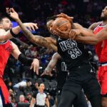 O pivô do Los Angeles Clippers, Brook Lopez (11), e o atacante Kawhi Leonard (2) jogam pela bola contra o pivô do Brooklyn Nets, Nic Claxton (33), durante o primeiro tempo no Intuit Dome.
