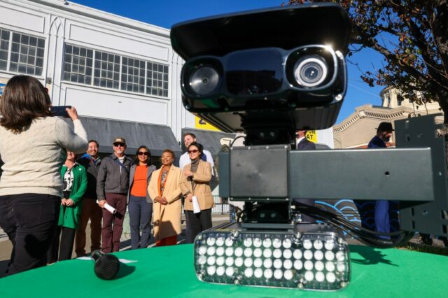 Um radar de velocidade automatizado é exibido em uma mesa enquanto a prefeita de Oakland, Barbara Lee, caminha em direção ao pódio para se dirigir à mídia durante uma entrevista coletiva no cruzamento da 27th Street com a Broadway em Oakland, Califórnia, na sexta-feira, 16 de janeiro de 2026. 18 câmeras foram instaladas em locais por toda a cidade e começaram a emitir avisos em 14 de janeiro de 2026. Eles estão programados para começar a emitir multas por excesso de velocidade em meados de março de 2026, de acordo com a cidade funcionários. (Ray Chavez/Grupo de Notícias da Bay Area)