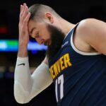O pivô do Denver Nuggets, Jonas Valanciunas, cobrindo a testa com a mão.