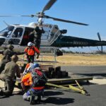 Membros da Unidade de Resgate de Riverside Mountain durante um exercício de treinamento com um helicóptero do xerife.