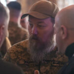 Madyar, em uniforme militar e boné de beisebol, fala com os ucranianos.