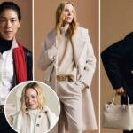 Uma mulher de jaqueta e calça pretas, segurando uma bolsa de tecido de cor clara.