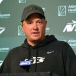 Um técnico do New York Jets gesticula na linha lateral.