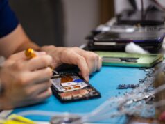 O grande erro que os DIYers cometem e que podem destruir seu laptop ou telefone Um telefone sobre uma mesa, conectado, com um logotipo de aviso na tela