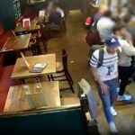 O ladrão de telefones Aouidj Abderaouf passa por uma mochila com a qual mais tarde fugiu. A bolsa é mostrada no canto inferior esquerdo deste vídeo