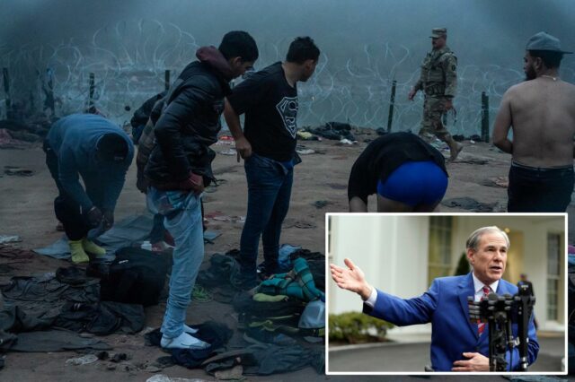 Os migrantes trocam de roupa na margem do rio, enquanto uma figura de autoridade dos EUA está por perto, com arame farpado ao fundo.