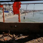 Palestinos caminham pelas ruínas da Cidade de Gaza.