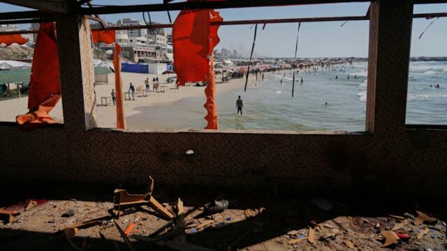 Palestinos caminham pelas ruínas da Cidade de Gaza.