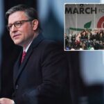 Um homem com cabelos grisalhos e óculos, vestindo um casaco preto e gravata vermelha, falando em um pódio.