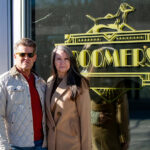 Os proprietários de Bourbon e Cigars do Boomer, Derrick DeSha, à esquerda, e Missy Baker, à direita, estão em frente ao bar ao longo da Coxe Avenue, em Asheville, em 12 de janeiro de 2025.