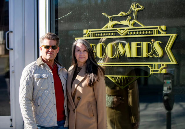 Os proprietários de Bourbon e Cigars do Boomer, Derrick DeSha, à esquerda, e Missy Baker, à direita, estão em frente ao bar ao longo da Coxe Avenue, em Asheville, em 12 de janeiro de 2025.