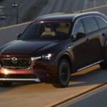 Um Mazda MX-5 Miata 2024 com o teto abaixado dirigindo em uma estrada