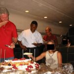 Bill Clinton, 79 anos, parecia estar cortando um grande bolo e servindo-o aos outros passageiros de um jato particular em uma foto sem data