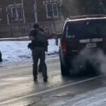 Um agente do ICE agarra a maçaneta da porta de seu carro momentos antes do tiroteio.