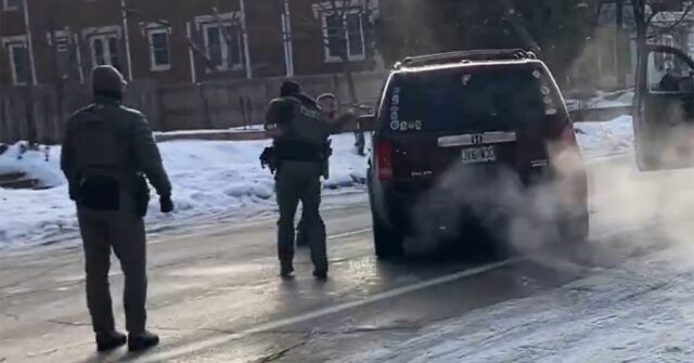 Um agente do ICE agarra a maçaneta da porta de seu carro momentos antes do tiroteio.