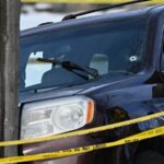 Um agente federal pulveriza um manifestante com um agente químico no local de um tiroteio em Minneapolis.