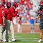 Head coach Brent Venables and running backs coach L'Damian Washington listen as tight ends coach Joe Jon Finley
