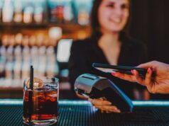 Os bartenders dizem que um pedido comum lhes custa gorjetas – e alguns clientes não têm ideia Um cliente pagando com um smartphone tocando em um terminal de pagamento segurado por um barman sorridente.