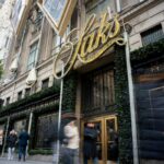 A principal loja da Saks na Quinta Avenida, em Nova York, com compradores desfocados passando.