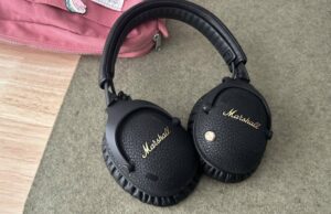 Os fones de ouvido Marshall Monitor III me fizeram perceber que os fones de ouvido de gama média não recebem atenção suficiente fones de ouvido Marshall em um tapete de mesa verde encostado em uma bolsa rosa