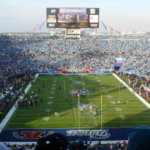 Evento SuperBowl, ampla visão do estádio, com gente em campo e torcedores ocupando os assentos. Os mercados de previsão FanDuel e DraftKings podem oferecer acumulações do Super Bowl, já que o CME emite autocertificação