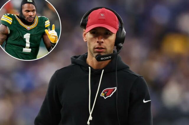 O técnico do Arizona Cardinals, Jonathan Gannon, usando um boné vermelho do Cardinals, moletom com capuz preto e fone de ouvido na linha lateral.