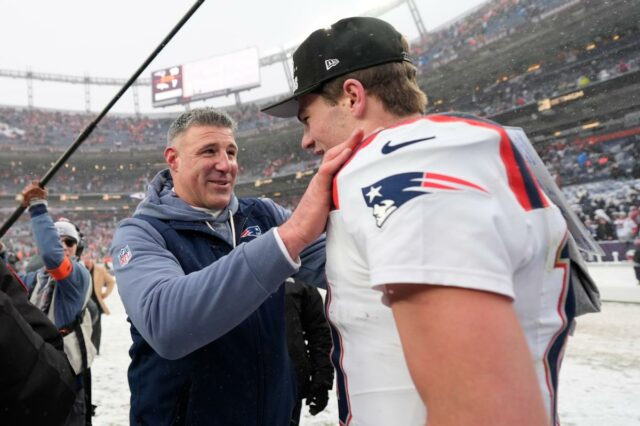 O técnico do New England Patriots, Mike Vrabel, fala com o quarterback Drake Maye após um jogo de futebol americano da NFL com neve.