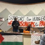 Uma sala com pôster com fotos de 8 grevistas de fome da Ação Palestina