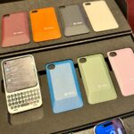 uma foto mostrando o dispositivo Clicks Communicator, com uma concha laranja e um botão de notificação vermelho iluminado na lateral.