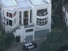 Proprietário atira em adolescente suspeito de roubo em casa de luxo em Los Angeles Vista aérea de uma casa branca de vários andares com um carro da polícia estacionado em frente.