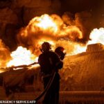 Um socorrista ucraniano trabalha para extinguir um caminhão de gasolina em chamas após um ataque aéreo em Kiev