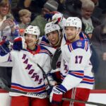 Jogador do New York Rangers contra jogador do Philadelphia Flyers durante um jogo da NHL.