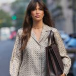 COPENHAGA, DINAMARCA - 05 DE AGOSTO: Um convidado veste uma jaqueta preta sob medida com corte estruturado e mangas três quartos, combinada com jeans azul escuro. Um lenço branco está pendurado no pescoço. Os acessórios incluem óculos de sol retangulares pretos e uma bolsa oval metálica prateada com alça. O calçado consiste em botas pretas de couro desleixadas com bico pontudo e salto alto, do lado de fora do Skall Studio, durante Copenhagen Fashion Week, em 05 de agosto de 2025 em Copenhague, Dinamarca (Foto de Edward Berthelot/Getty Images)