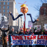Manifestantes marcham em frente ao Centro Milken para o Avanço do Sonho Americano, durante uma