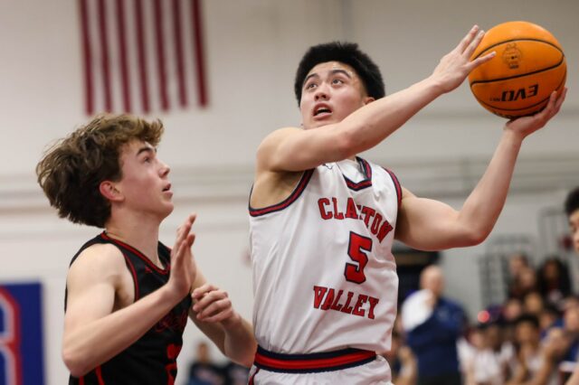 Rodada de basquete: a defesa sufocante de Clayton Valley sufoca Vince Ellis (3) de Clayton Valley vai até o aro enquanto Dominic Byra (10) de Campolindo defende durante um jogo de basquete na'Clayton Valley Charter High School em Cponcord, Califórnia, na terça-feira, 20 de janeiro de 2026. (Ray Chavez/Bay Area News Group)