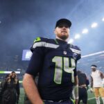 O quarterback do Seattle Seahawks, Sam Darnold, entra em campo após um jogo dos playoffs da NFL.