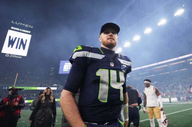 O quarterback do Seattle Seahawks, Sam Darnold, entra em campo após um jogo dos playoffs da NFL.