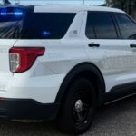 Veículo de patrulha do xerife do condado de White Clay com luzes azuis piscando.