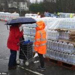 Um cliente da South East Water coleta água engarrafada em uma estação em East Grinstead na terça-feira
