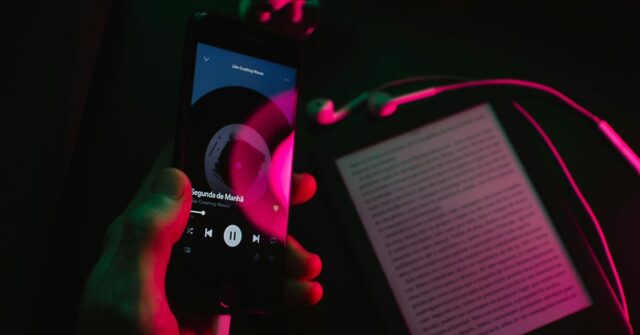 Spotify aumenta preços nos EUA em 8%, deixa pelo menos algumas pessoas felizes | Aplicativo visto em um smartphone com um Kindle em segundo plano