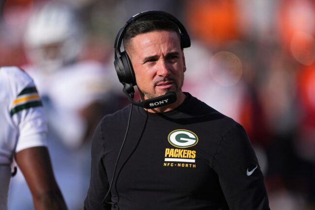 Status do trabalho de Matt LaFleur com Packers em questão O técnico do Green Bay Packers, Matt LaFleur, vestindo um fone de ouvido e uma camisa preta de mangas compridas com o logotipo dos Packers.